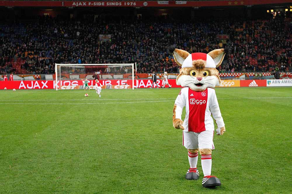 Maskotten for Ajax Amsterdam går på fodboldbanen med tilskuerne i ryggen